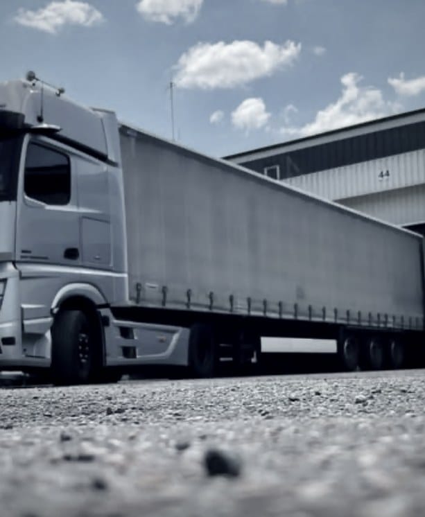 Actros mit Planenauflieger in bodennaher Seitenansicht